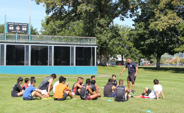 輪になってコーチの話を聞く